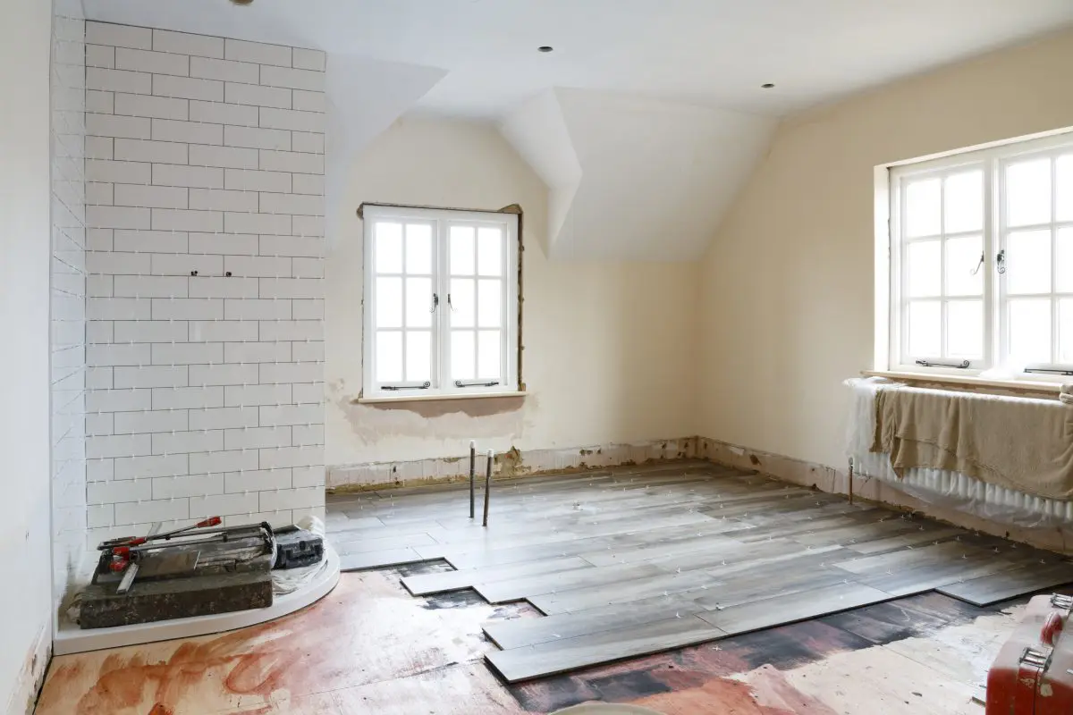 Room under renovation with tiled corner fireplace.