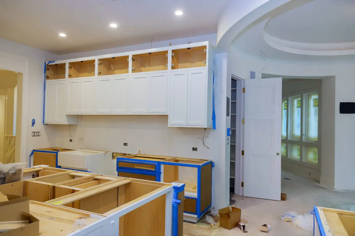 Kitchen under renovation with white cabinets.