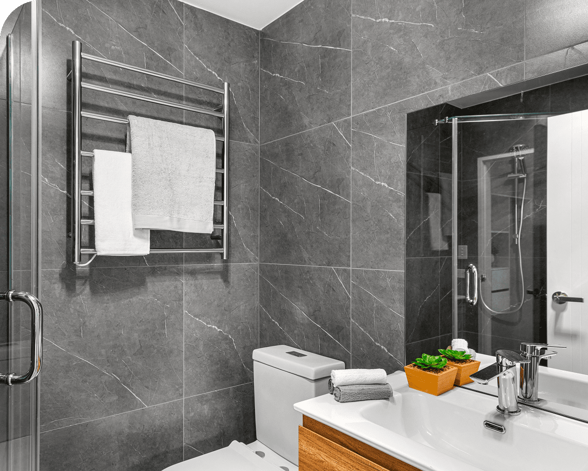 Modern bathroom with gray tiles and mirror.