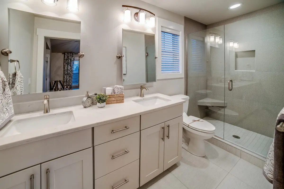 Modern bathroom with dual sinks and shower.